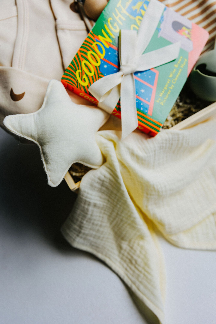 Close up of Love you to the Moon newborn gift box with Goodnight Moon boardbook, star lovey, and onesie