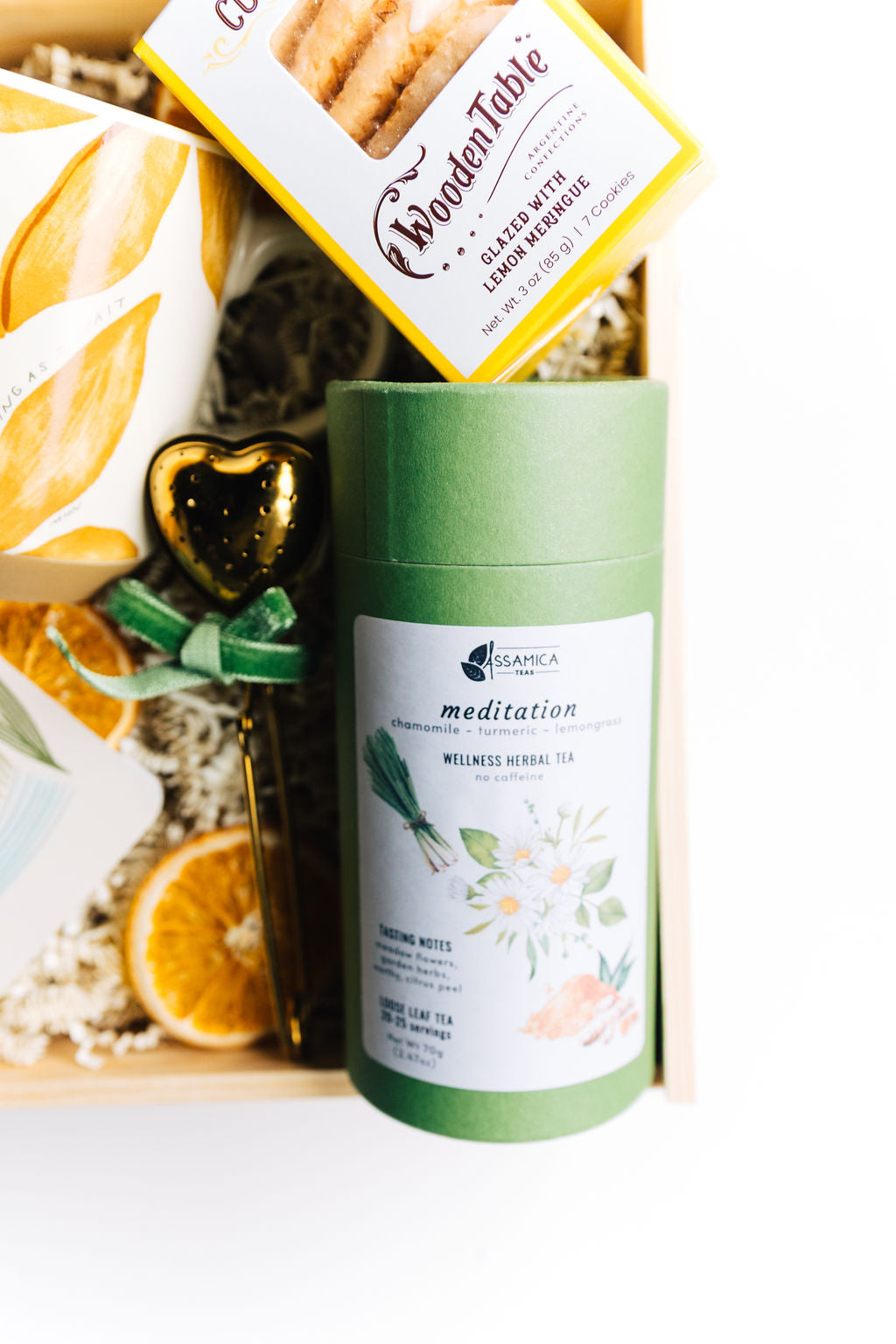 Lemon meringue cookies and herbal tea canister in Steeped in Stillness gift box, styled with dried orange slices