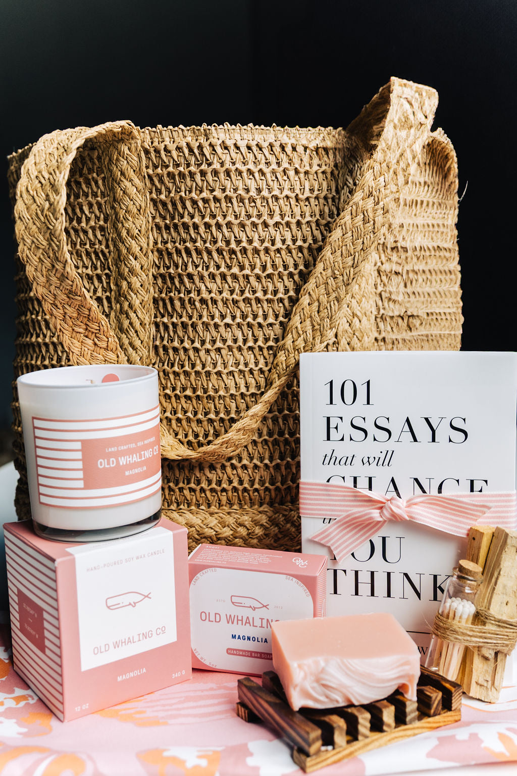 Sunshine in a Bag gift set with natural straw tote, magnolia candle, artisan soap, bamboo soap dish, book 101 Essays That Will Change the Way You Think, and Palo Santo matches