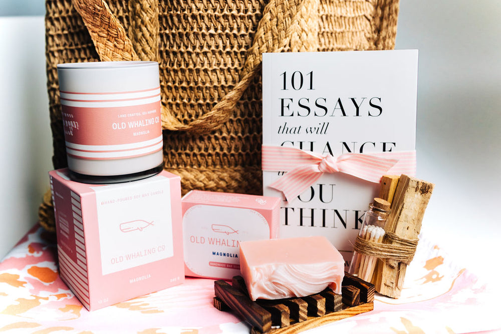 Coastal-inspired Sunshine in a Bag gift box featuring straw tote, blush magnolia candle, artisan soap, bamboo soap dish, Palo Santo matches, and inspirational book