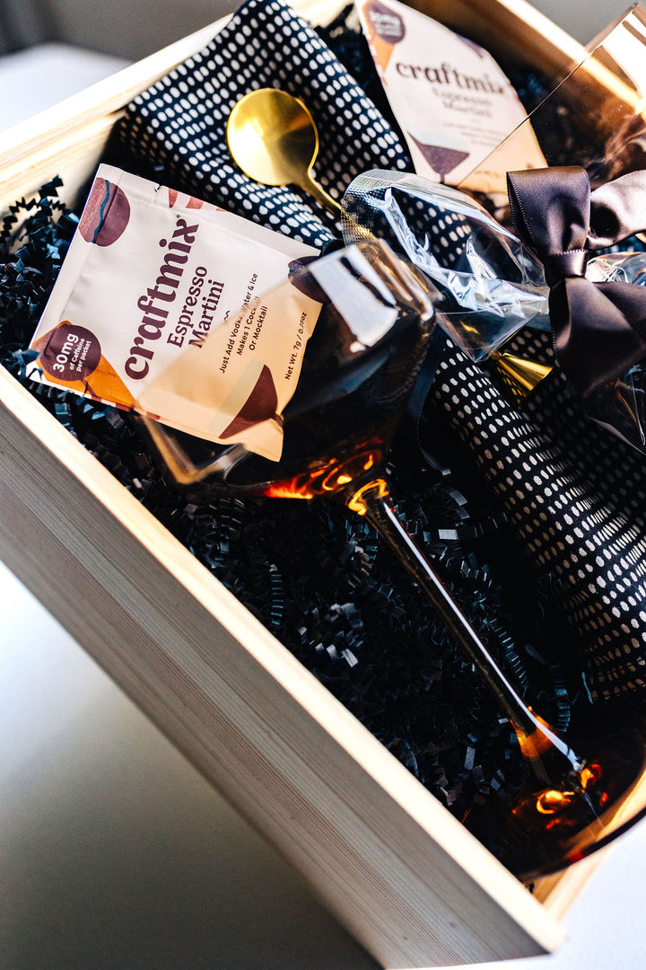 Close-up of Viski amber coupe glasses and cocktail ingredients in luxury gift box