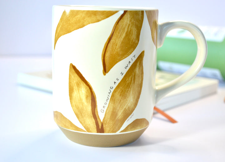Close-up of ceramic mug with hand-painted golden leaves and quote “Growing As I Wait” – part of Steeped in Stillness Tea Gift Box