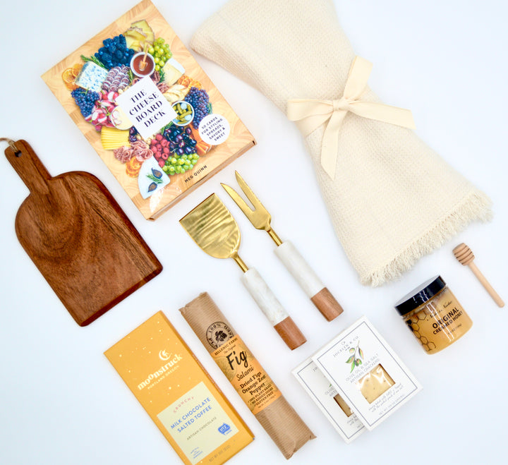 Flat lay of gourmet charcuterie gift box styled with artisan snacks and accessories