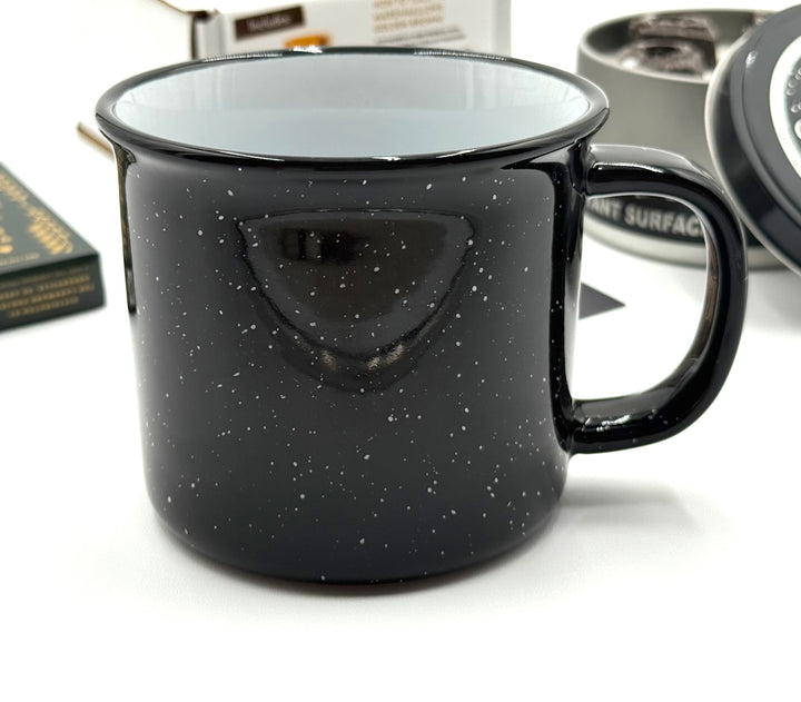 Classic enamel-style mug with white speckles, ideal for sipping hot drinks fireside
