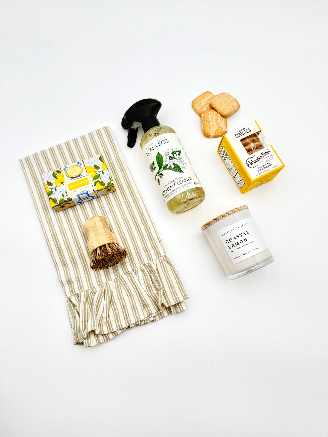 Flat lay of Home Sweet Home Gift Box contents – candle, cleaner, scrub brush, towel, cookies, and soap